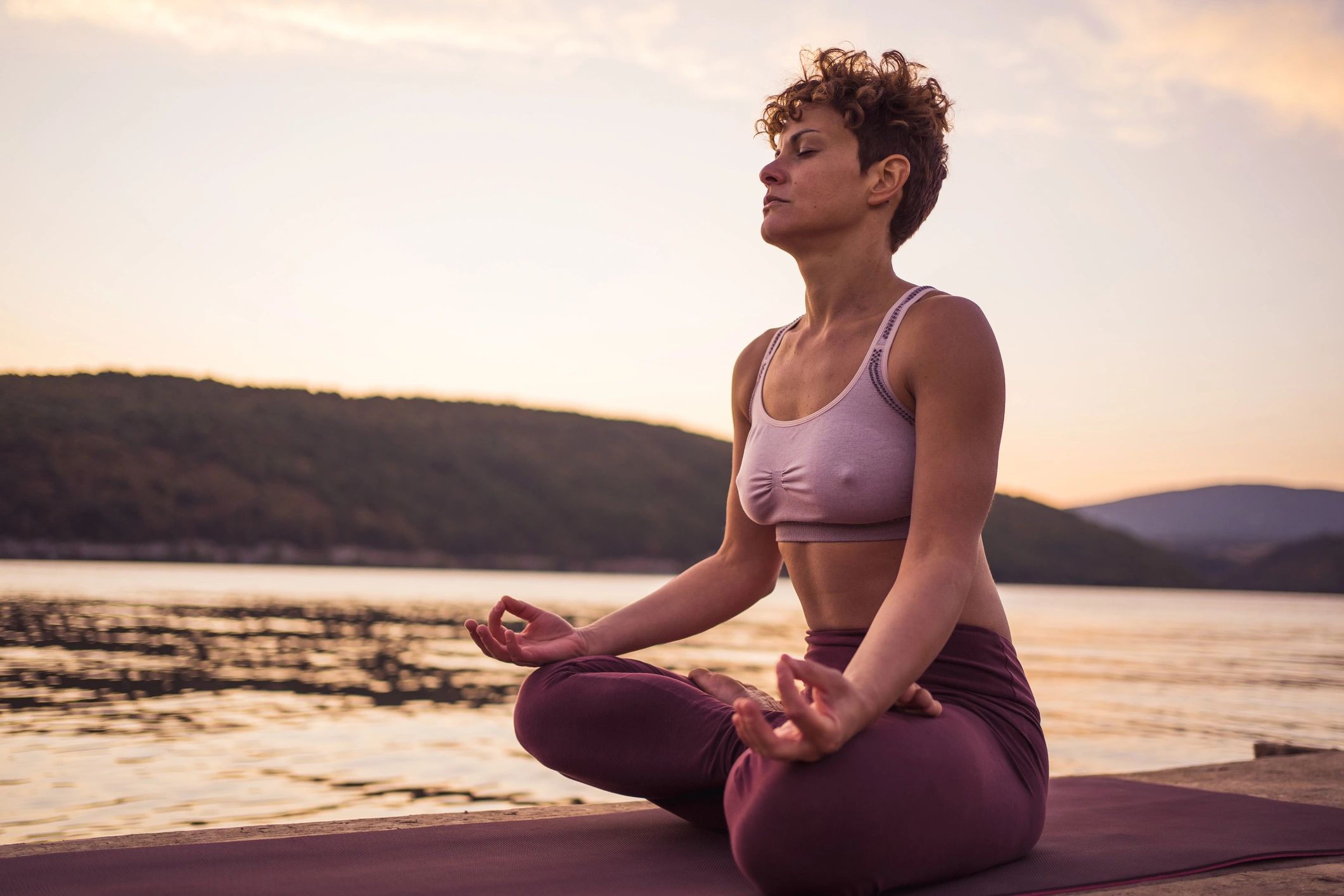 Woman meditating peacefully by the water